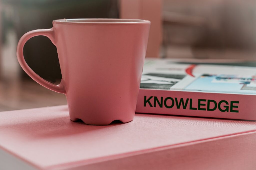 a mug next to the word "knowledge" on a book