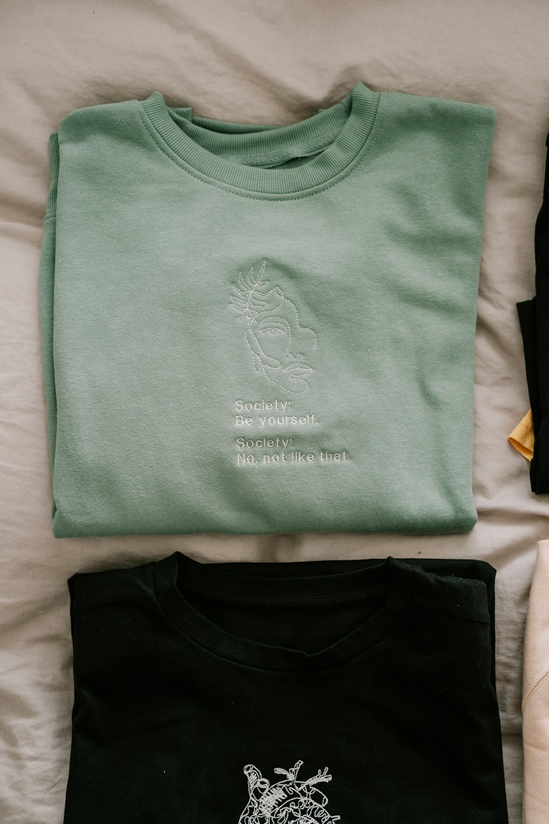 Embroidery design by Popular Brands green crew neck shirt on white textile