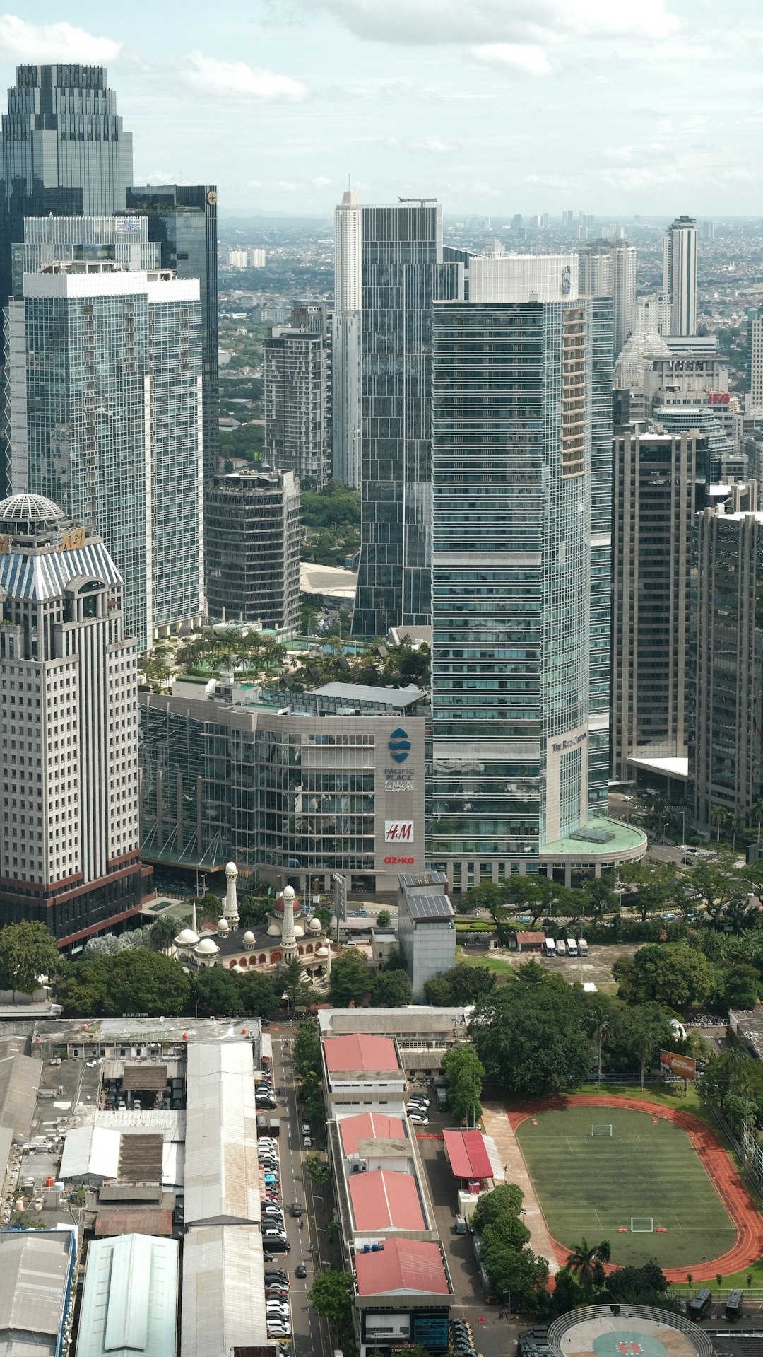 The Revenue Revolution: A Whirlwind History of Global Corporate Powerhouses by Popular Brands Cityscape with tall buildings and a sports field.